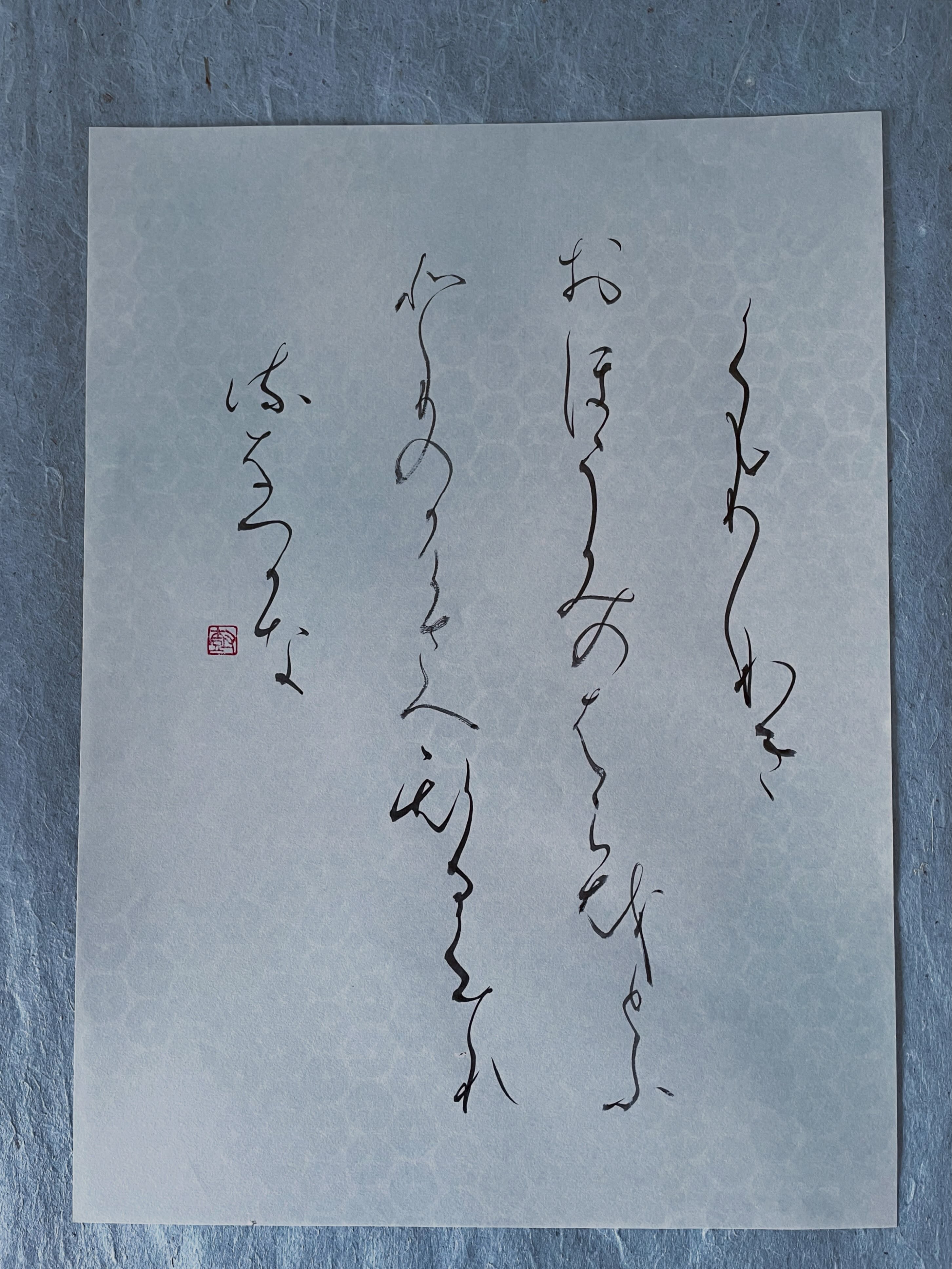 涼やかな青灰色の料紙に書かれた、講師による8月のかな課題作品