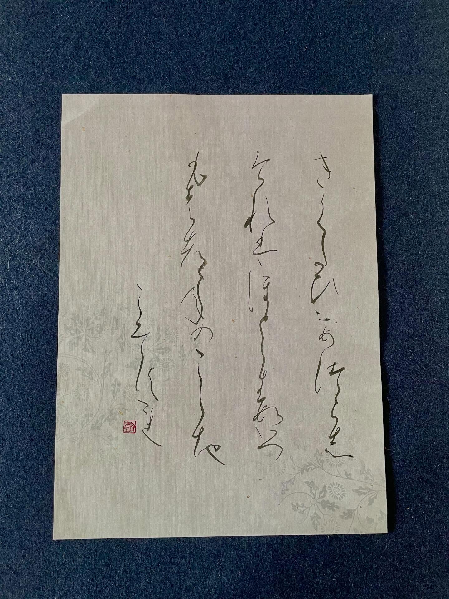 淡い花模様の料紙に、流れる仮名が書かれた講師の作品